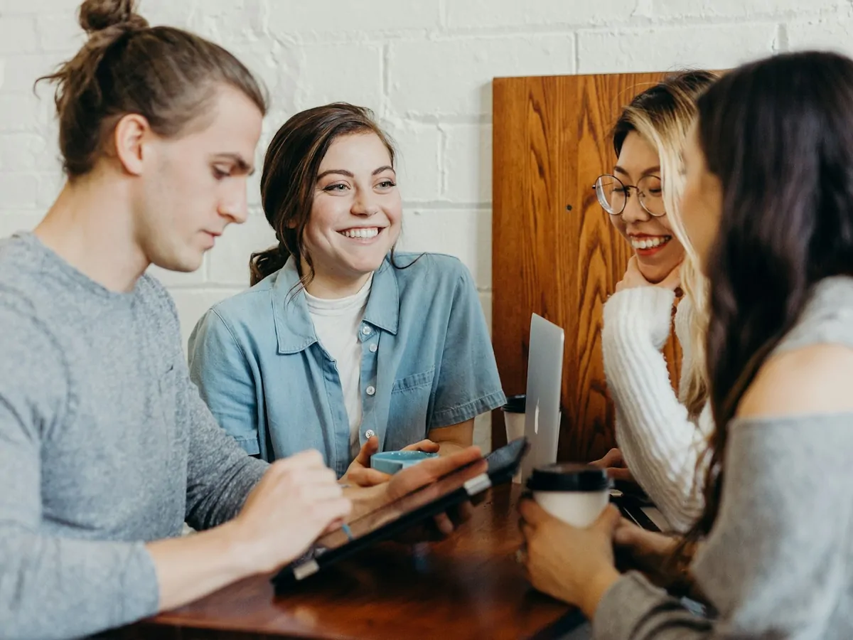 Four Silex colleagues talking around a table with a tablet and laptop