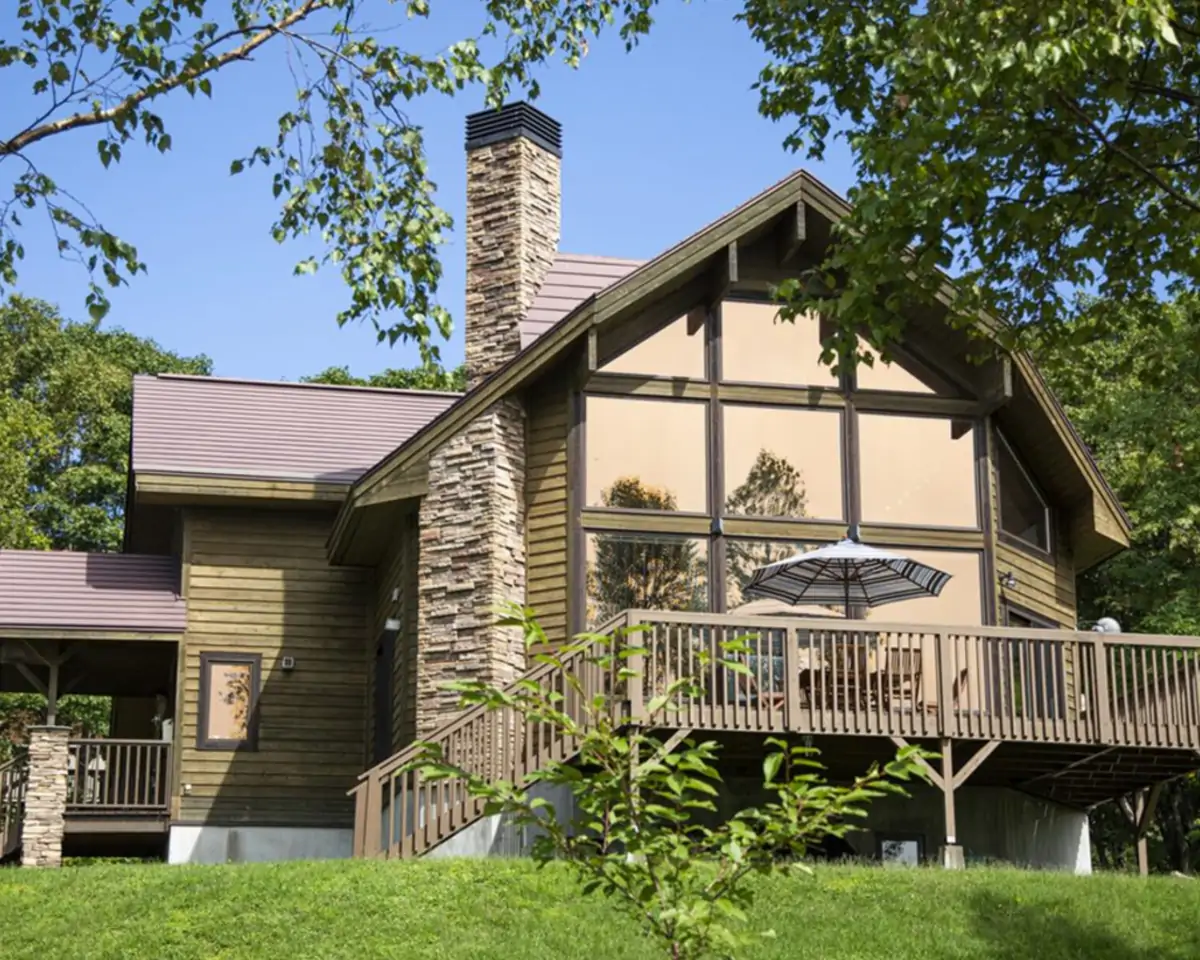 Timber vacation-rental lodge with a deck, set among trees